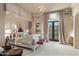 Stately primary bedroom with luxe drapery, upholstered headboard, french doors and neutral decor under a chandelier at 20715 N 103Rd Pl, Scottsdale, AZ 85255