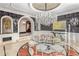 Grand dining room featuring a large crystal chandelier, unique flooring, and adjacent hallway at 20715 N 103Rd Pl, Scottsdale, AZ 85255