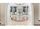 Elegant dining room featuring a large chandelier, glass table, and decorative flooring at 20715 N 103Rd Pl, Scottsdale, AZ 85255