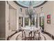 Elegant dining room featuring a custom chandelier, white dining set, and bright decor under a decorative dome at 20715 N 103Rd Pl, Scottsdale, AZ 85255