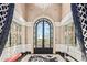 Elegant foyer featuring an arched glass door with black trim, chandelier, and marble flooring with designer rug at 20715 N 103Rd Pl, Scottsdale, AZ 85255