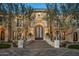 Stunning front exterior featuring a grand entrance with an arched doorway and meticulously landscaped yard at 20715 N 103Rd Pl, Scottsdale, AZ 85255