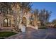 Elegant house showcasing an impressive entryway with an arched doorway and a lush, green lawn at 20715 N 103Rd Pl, Scottsdale, AZ 85255