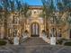 Stunning front exterior featuring a grand entrance with an arched doorway and meticulously landscaped yard at 20715 N 103Rd Pl, Scottsdale, AZ 85255