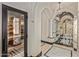 Hallway with arched ceilings, marble floors and see-through doors leading to the steam room, bath, and other rooms at 20715 N 103Rd Pl, Scottsdale, AZ 85255