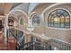 Hallway featuring a beautiful chandelier, arched windows, and refined architectural details at 20715 N 103Rd Pl, Scottsdale, AZ 85255