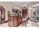 Kitchen with bar seating, custom wood cabinets, and a view to the rest of the house at 20715 N 103Rd Pl, Scottsdale, AZ 85255