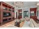 Spacious living room with built-in shelving, a stylish chandelier, and hardwood flooring at 20715 N 103Rd Pl, Scottsdale, AZ 85255