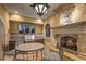 Inviting outdoor kitchen featuring stainless steel appliances, a stone fireplace, and travertine flooring at 20715 N 103Rd Pl, Scottsdale, AZ 85255