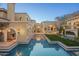 Expansive backyard showcasing a pristine pool, manicured landscaping, and elegant outdoor living spaces with refined arches at 20715 N 103Rd Pl, Scottsdale, AZ 85255