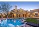 Stunning backyard view of an estate featuring a luxurious pool, manicured lawn, and elegant architectural details at 20715 N 103Rd Pl, Scottsdale, AZ 85255