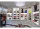 Luxurious walk-in closet featuring custom shelving with handbags, shoes and display lighting under an attractive pendant chandelier at 20715 N 103Rd Pl, Scottsdale, AZ 85255