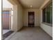 Covered entryway with a dark wood front door, neutral paint, and recessed lighting at 20951 E Via Del Sol St, Queen Creek, AZ 85142