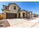Inviting two-story home boasting a spacious driveway and a neatly landscaped front yard with young trees at 20951 E Via Del Sol St, Queen Creek, AZ 85142