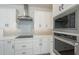 Close-up of kitchen appliances, including a KitchenAid microwave and oven, plus sleek white cabinetry at 2121 W Sonoran Desert Dr # 13, Phoenix, AZ 85085