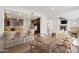 Stylish dining area with modern table, bar seating, and view into the living room with fireplace at 21320 N 56Th St # 1085, Phoenix, AZ 85054