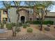 Two-story home with stone and stucco accents, mature trees, and desert landscaping at 21320 N 56Th St # 1085, Phoenix, AZ 85054