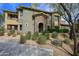 Multi-story home exterior featuring stone accents, covered balconies, and desert landscaping at 21320 N 56Th St # 1085, Phoenix, AZ 85054