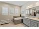 Bright bathroom featuring a soaking tub, dual sink vanity, and plantation shutters at 21432 W Minnezona Ave, Buckeye, AZ 85396