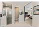 Bright bathroom featuring a tiled shower, toilet, and access to the bedroom at 21432 W Minnezona Ave, Buckeye, AZ 85396