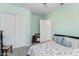 Bedroom with mint green walls, closet and view into another room at 21432 W Minnezona Ave, Buckeye, AZ 85396