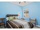 Cozy bedroom with blue accent walls, a ceiling fan, and natural light at 21432 W Minnezona Ave, Buckeye, AZ 85396