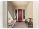 Welcoming courtyard features a red door framed by decorative shutters and two benches with yellow pillows at 21432 W Minnezona Ave, Buckeye, AZ 85396