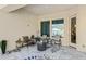 Covered patio area with neutral color tones, tile flooring, and cushioned seating for outdoor relaxing at 21432 W Minnezona Ave, Buckeye, AZ 85396