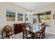 Dining room with windows overlooking the pool area, with designer chandelier and wood furniture at 21432 W Minnezona Ave, Buckeye, AZ 85396