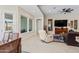 Living room with tile flooring, a ceiling fan, a view of the backyard, and neutral paint colors at 21432 W Minnezona Ave, Buckeye, AZ 85396