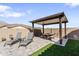 Backyard pergola seating area featuring a picnic table, lounge seating, paved patio, and artificial turf at 21432 W Minnezona Ave, Buckeye, AZ 85396