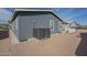 Back exterior view showcasing the home's siding, gravel landscaping, and AC unit at 2206 S Ellsworth Rd # 50B, Mesa, AZ 85209