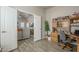 Bright office space with wood-style flooring, a large desk, and views into the living room, perfect for working from home at 2206 S Ellsworth Rd # 50B, Mesa, AZ 85209