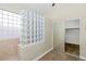 Bathroom featuring a glass block accent wall and a sliding glass door to closet at 22722 N 120Th Ln, Sun City, AZ 85373