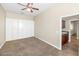 A bedroom featuring a ceiling fan, and floor to ceiling built-in wardrobes at 22722 N 120Th Ln, Sun City, AZ 85373