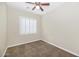 Cozy bedroom featuring neutral walls, brown carpet and a ceiling fan with light at 22722 N 120Th Ln, Sun City, AZ 85373