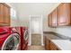 A laundry room that has cherry red washer and dryer and ample cabinet space at 22722 N 120Th Ln, Sun City, AZ 85373