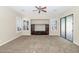 A living room featuring a ceiling fan, built-in shelving, and large glass doors at 22722 N 120Th Ln, Sun City, AZ 85373