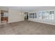 Bright open-concept living room with neutral carpeting, plantation shutters, and views into the kitchen at 22722 N 120Th Ln, Sun City, AZ 85373