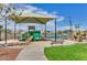 Community playground with modern play structure, shade, seating, and view of the tennis court at 22722 N 120Th Ln, Sun City, AZ 85373