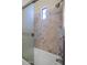 Tile shower and tub featuring a glass shower door and square pattern tile at 22722 N 120Th Ln, Sun City, AZ 85373
