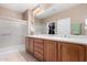 Bright bathroom features double sinks, wood cabinets, large mirror and glass enclosed shower at 26485 W Yukon Dr, Buckeye, AZ 85396