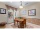 Bright dining area with wood table, stylish lighting, and sliding glass door to patio at 26485 W Yukon Dr, Buckeye, AZ 85396