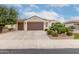 Charming home featuring a tile roof, mature landscaping, and a spacious driveway with a three-car garage at 26485 W Yukon Dr, Buckeye, AZ 85396