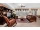 Comfortable living room with a ceiling fan, built-in shelves, and a view to the backyard at 26485 W Yukon Dr, Buckeye, AZ 85396