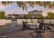 Relaxing outdoor area with chairs around fire pit, next to a brick wall water feature and homes in the background at 3294 W Storm Cloud St, San Tan Valley, AZ 85144