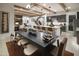 Open concept living and dining area, wood beam ceilings, and a modern kitchen island with bar seating at 3307 W Storm Cloud St, San Tan Valley, AZ 85144