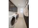 Functional laundry room with washer, dryer, storage cabinets, and a convenient folding area at 3307 W Storm Cloud St, San Tan Valley, AZ 85144