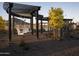 Relaxing swing set area with comfortable white swings under a stylish pergola in a landscaped setting at 3307 W Storm Cloud St, San Tan Valley, AZ 85144