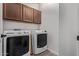 The laundry room features modern machines, wood cabinets and neutral paint at 3595 E Desert Moon Trl, San Tan Valley, AZ 85143